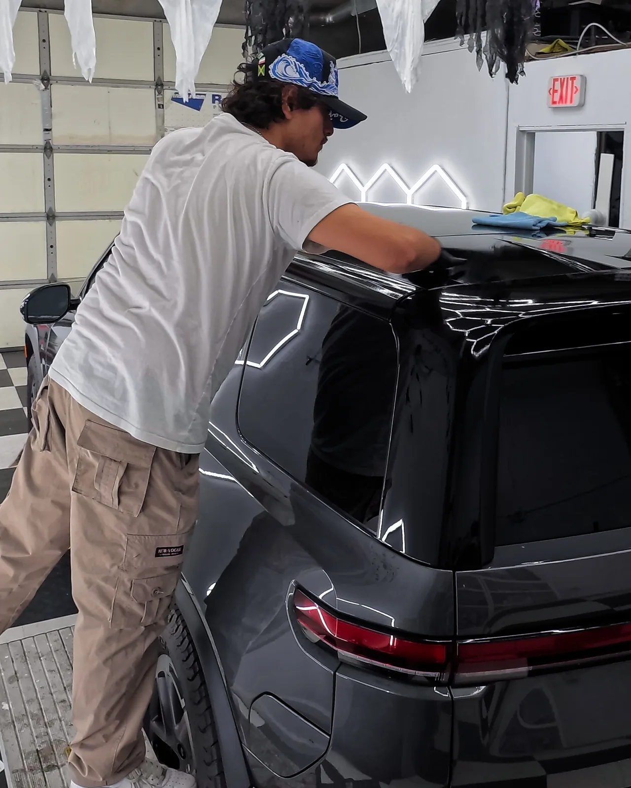 Oka working on the roof of the Rivian R2 — Oka's Car Care, Mountain View