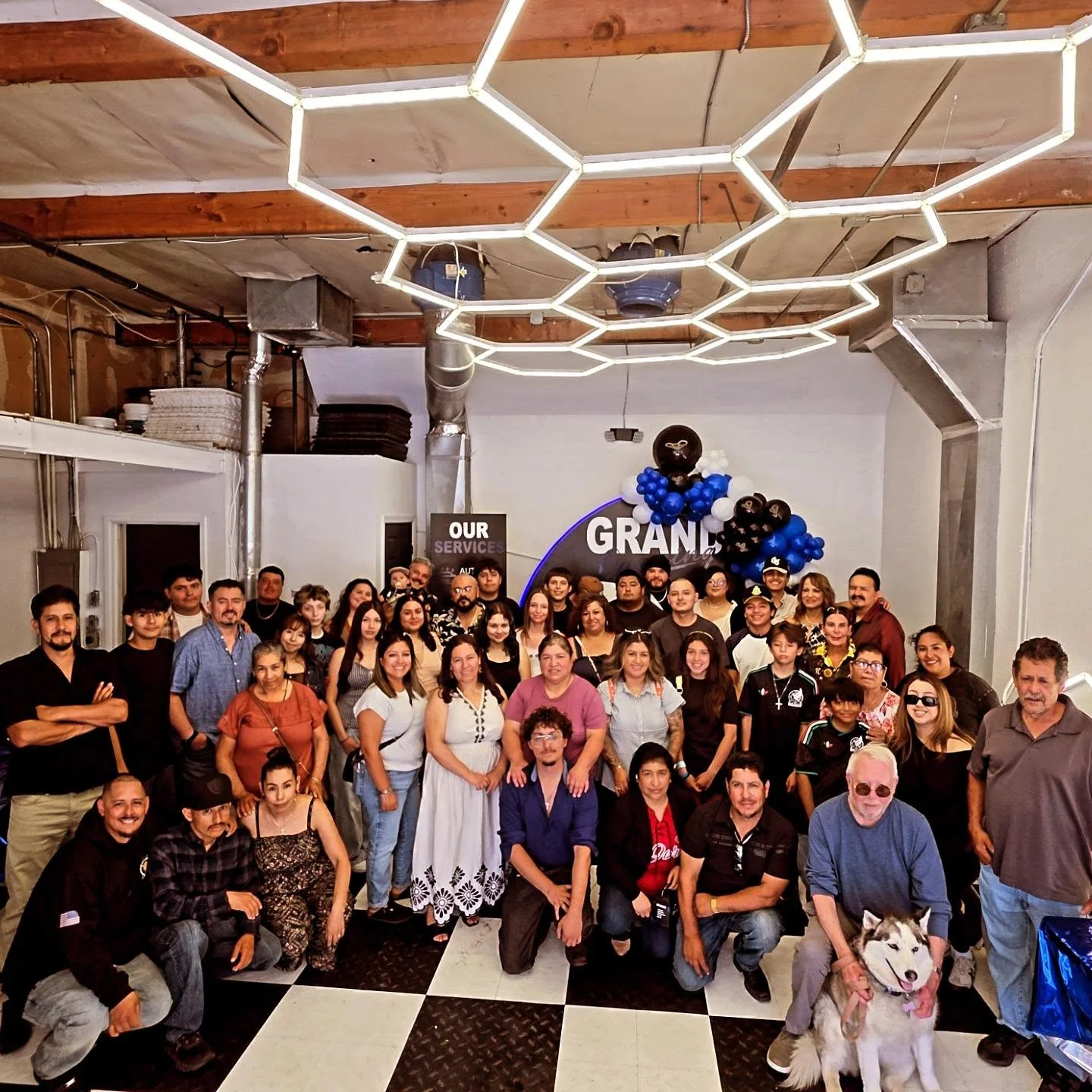Family and friends in the bay at the opening of Oka's Car Care, Mountain View, August 2026