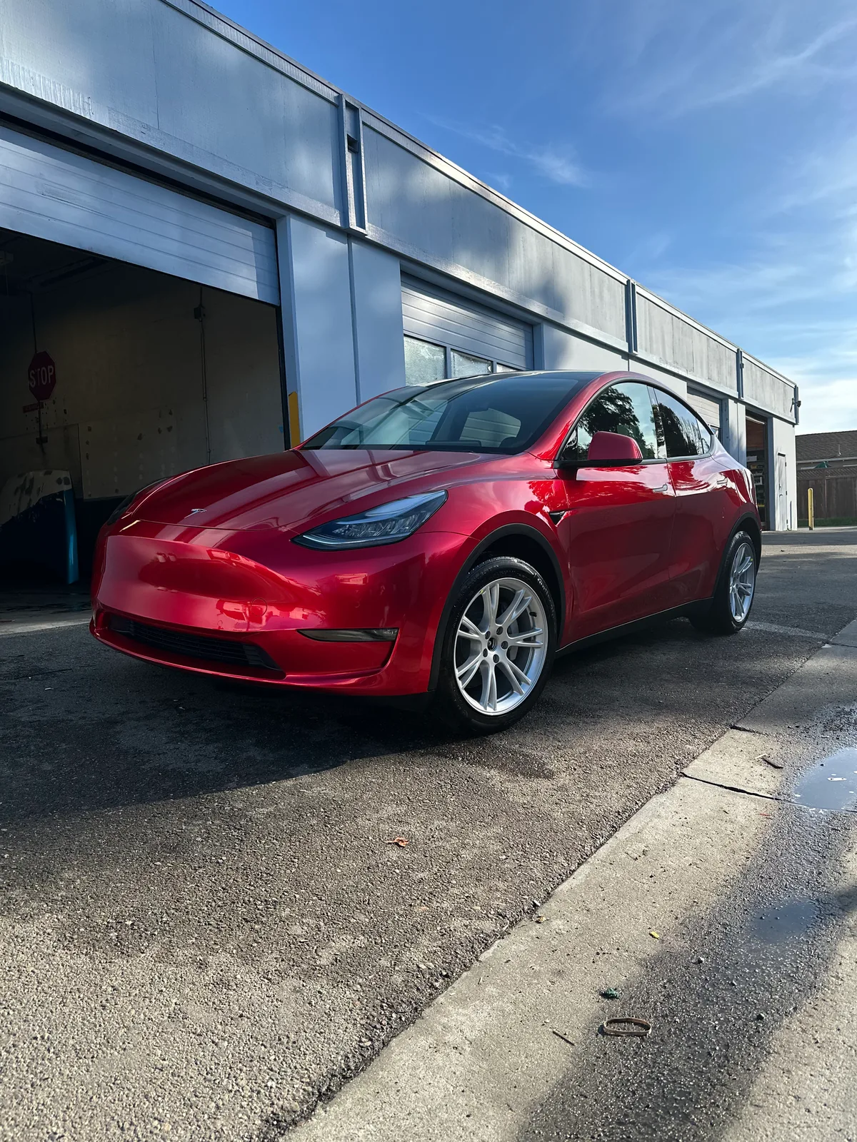 Tesla Model Y in red at the Oka's Car Care shop door, Mountain View